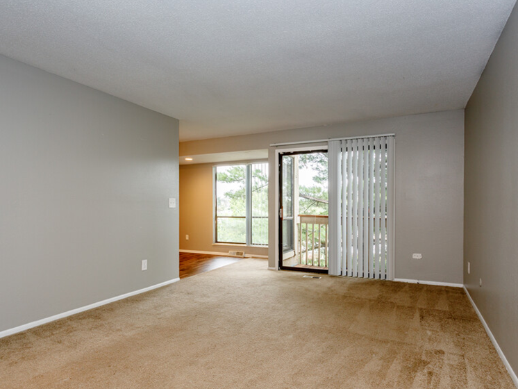 large carpeted room with sliding glass door